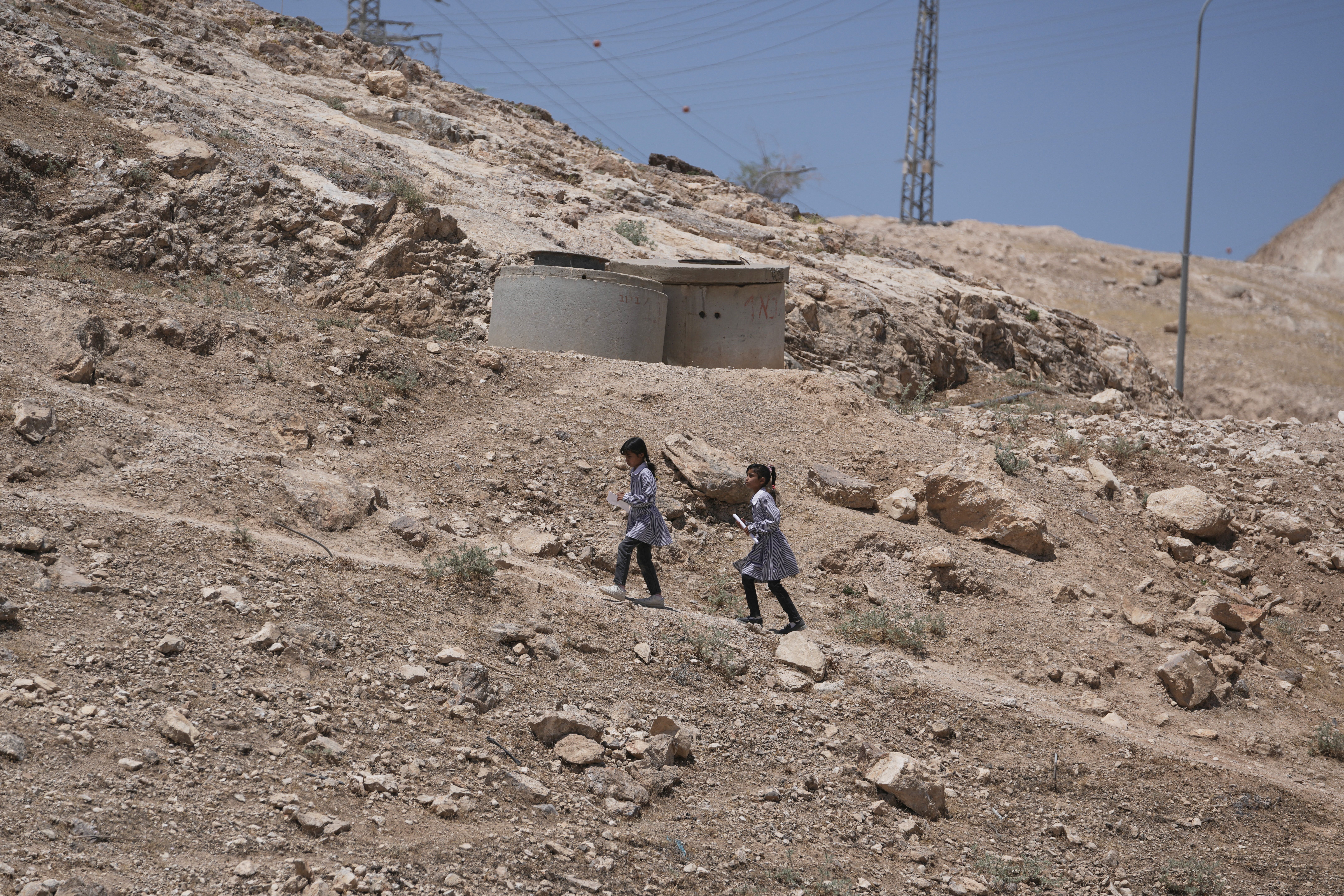 Palestinian students walk on their way home after receiving their year end reports from school, in the West Bank Bedouin hamlets of Khan al-Ahmar, Wednesday, June 10, 2026.